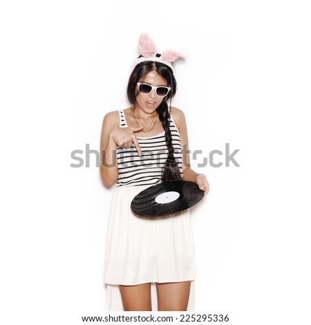 Young teenage girl in pink bunny ears. Sweet woman having fun with musical plate on white background, not isolated
