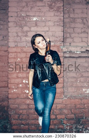 Bad girl lighting up a cigarette from Molotov cocktail bomb in her hand.  Outdoor lifestyle portrait