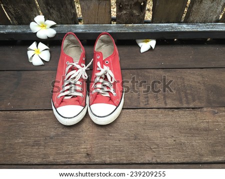 red sneakers on wooden deck