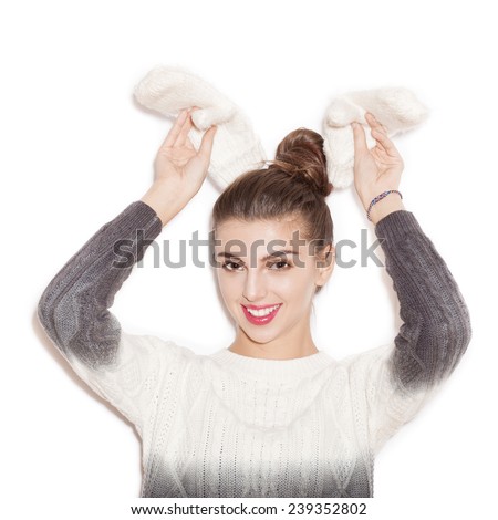 Happy young woman experiencing the joy. Beautiful Girl  with rabbit ears of mittens. Emotion.  Hairstyle. Make-up.  White background, not isolated