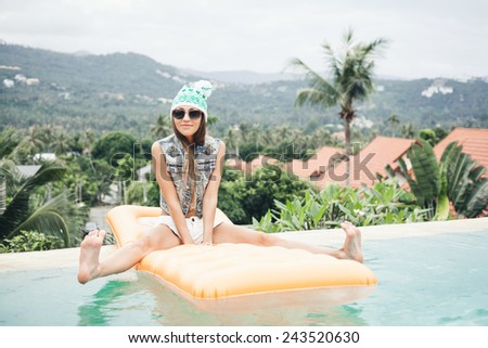 Young pretty fashion sport woman posing outdoor in summer on tropic island in hot weather in bikini on pool party
