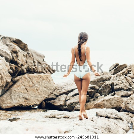 Girl walking on rocks by ocean. Well being healthy lifestyle