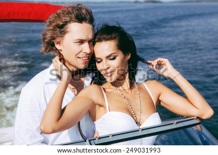 Young couple kissing each other. Man and woman on a sea voyage on a yacht.