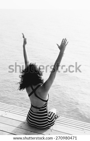 Freedom and happiness woman on pier. Girl enjoying serene ocean nature during travel holidays vacation outdoors
