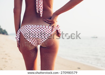 Sexy back of a beautiful woman in bikini on sea background. Sexy buttocks. Toned