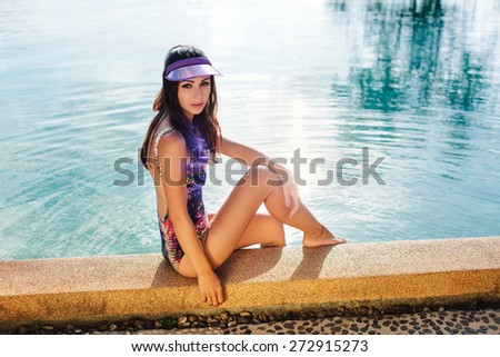 Young pretty fashion sport woman posing outdoor in summer on tropic island in hot weather in bikini on pool party. Outdoors lifestyle portrait