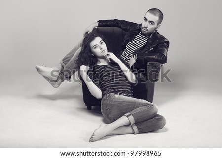 a beautiful young couple with bare feet sitting on a chair