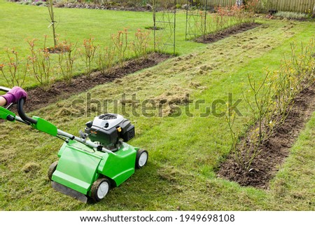 Similar – Image, Stock Photo Spring gardening. Scarify, aerate lawn in the garden to improve the quality of the lawn in the spring.