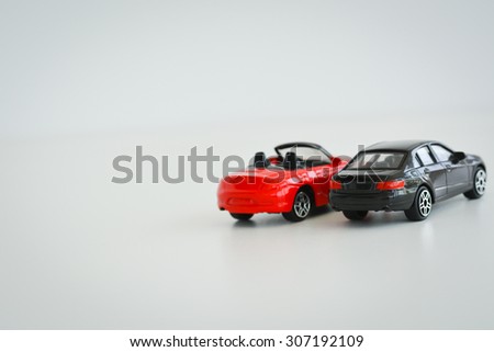 Black and red toy cars on white background suggesting a competition