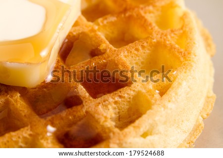 Waffle - This is a shot of a waffle with a slice of butter sitting on a plate getting covered with syrup. Shot with a shallow depth of field.