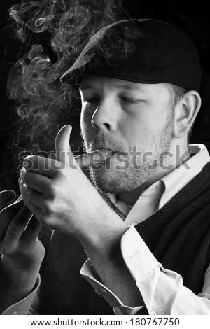Smoking A Cigar - This is a high contrast black and white image of a young man lighting his cigar. Shot on a black background and processed slightly to enhance detail.