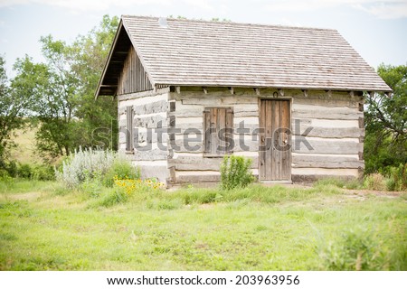Log Cabin - This is a shot of a little log cabin sitting alone surrounded by tall prairie grass. Shot with a shallow depth of field.