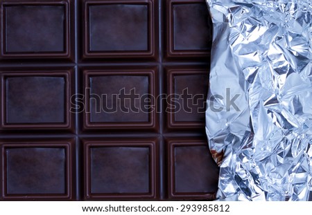 Tile dark chocolate wrapped in foil. background.plan view