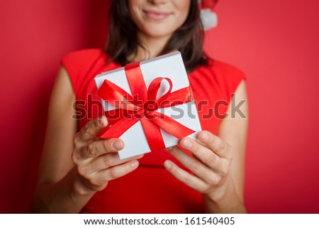 Christmas Santa hat isolated woman portrait hold christmas gift. Smiling happy girl on background.