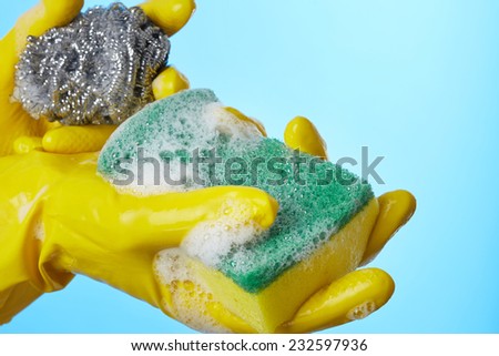 Woman\'s hands in gloves with sponge for wash dishes