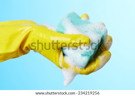 Woman\'s hands in gloves with sponge for wash dishes