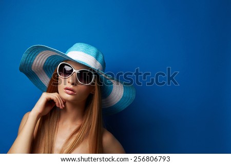 Beautiful Young woman in hat on blue background