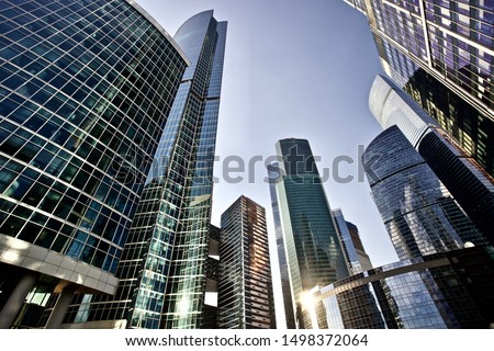Office and residential skyscrapers on bright sun and clear blue sunset sky background. Commercial real estate. Modern business city district. Office buildings exterior. Financial city district. 