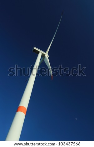 Wind turbine against deep blue sky - vertical orientation