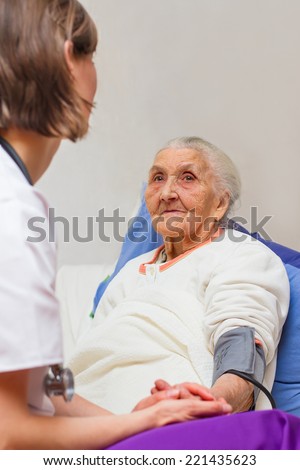 Young  nurse caring for  elderly patients helping their days in nursing home.