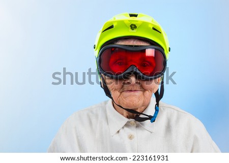 funny grandma wearing a yellow bicycle helmet and ski  goggles