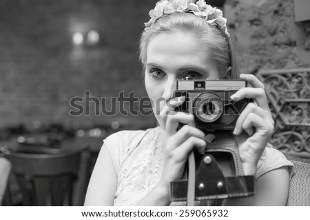 Black and white image of a kind woman with camera.