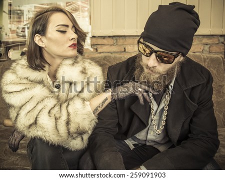 Strange couple sitting at home together on a couch.
