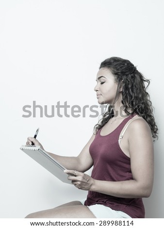 Attractive young woman of color holds a pen and clipboard