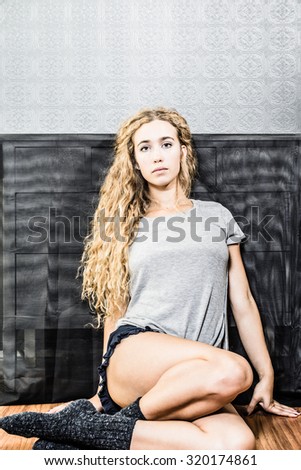 Woman with naturally curly long blonde hair sitting down