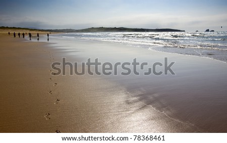 People at beach and footprints in sand