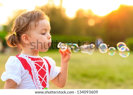 Little girl blowing soap bubbles