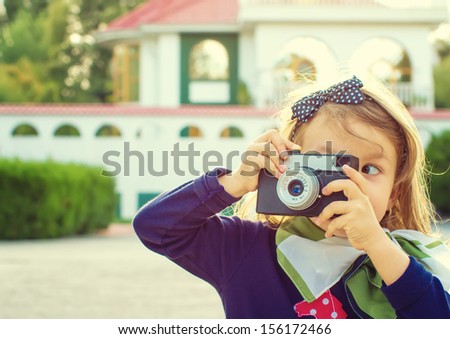 Little girl taking  picture using vintage film camera