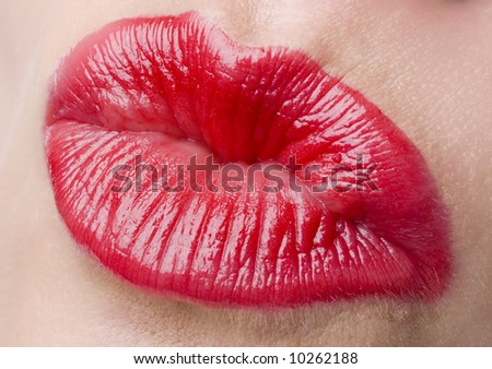 Glamour Red gloss lips with kissing gesture.