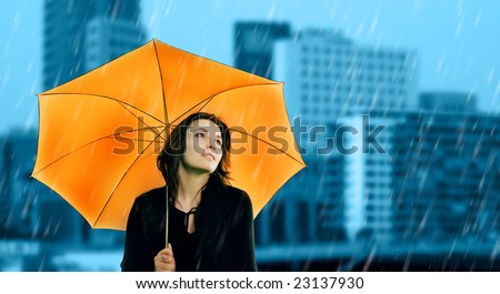 Beautiful young woman with orange umbrella on rainy day