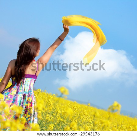 beautiful young woman on rapeseed field with yellow scarf