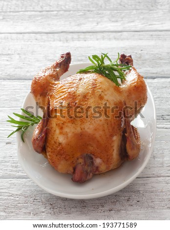 Fried chicken with rosemary over old wood background
