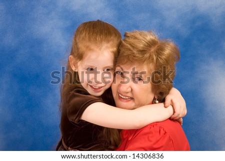 Portrait of grandmother hugging six year old girl smiling and happy