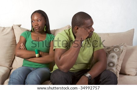 Young black ethnic African-American couple at odds and bad mood not talking with each other and looking away after heated argument