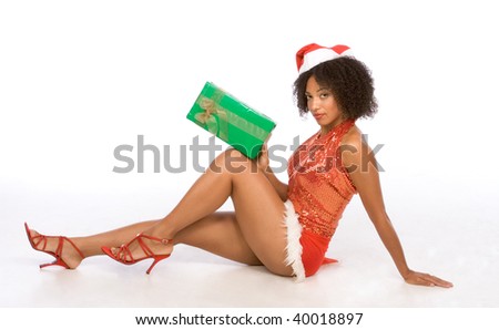 Sexy female in Christmas outfit sitting on floor and holding big Christmas gift box