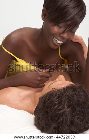 Happy young ethnic black African American woman and mid aged Caucasian man in bed interacting and making love