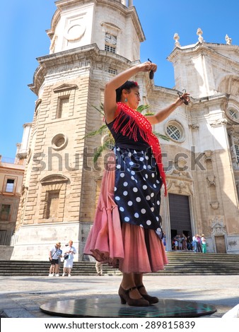 CADIZ - MAY 29: women in traditional flamenco dress  dance  in front of cathedral on may 29, 2015 in Cadiz, Spain.