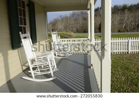 White Rocking Chairs on Front Porch with Picket Fence