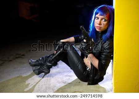 Sexy woman with blue hair holding two guns and looking as killer