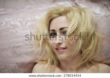 Young beautiful girl wakes up in the morning in a bed