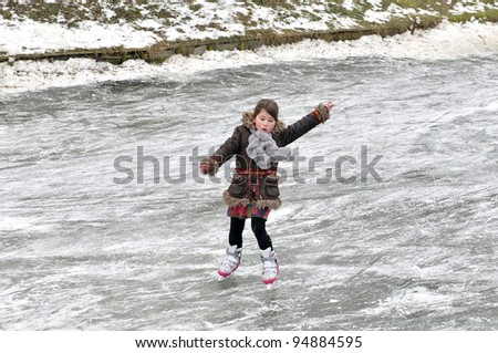 little girl learning ice skating outdoors