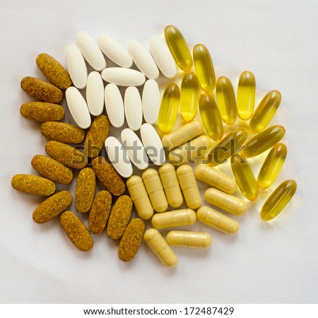 white and yellow pills isolated on white background with shadows