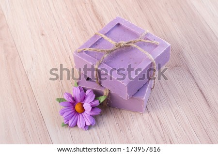 handmade soap and paper flower on wooden background