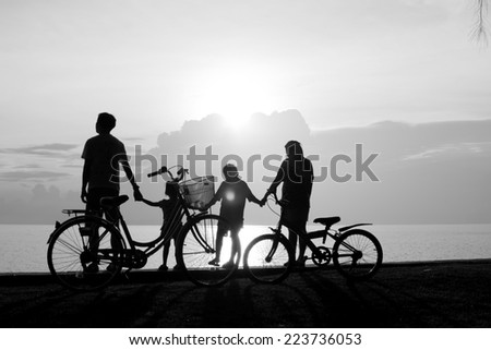 Biker family silhouette , family on the beach at sunset.