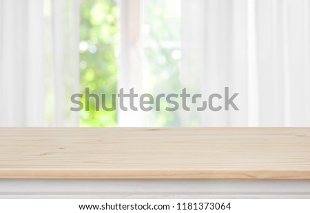 Wooden empty table in front of blurred curtained window background Foto d'archivio © 