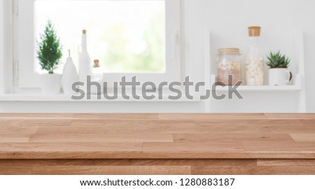 Wooden tabletop in front of blurred kitchen window, shelves background Stockfoto © 
